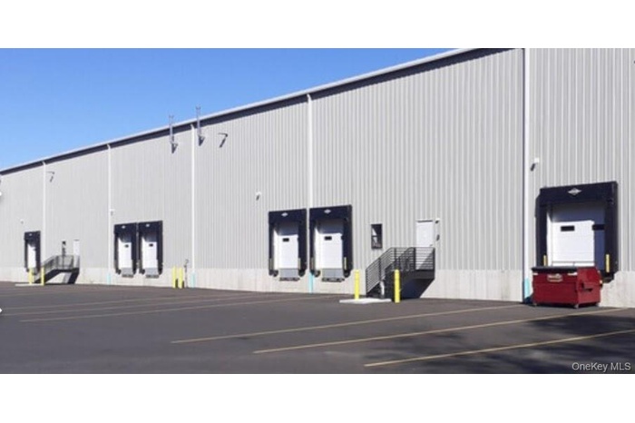 View of building exterior with uncovered parking