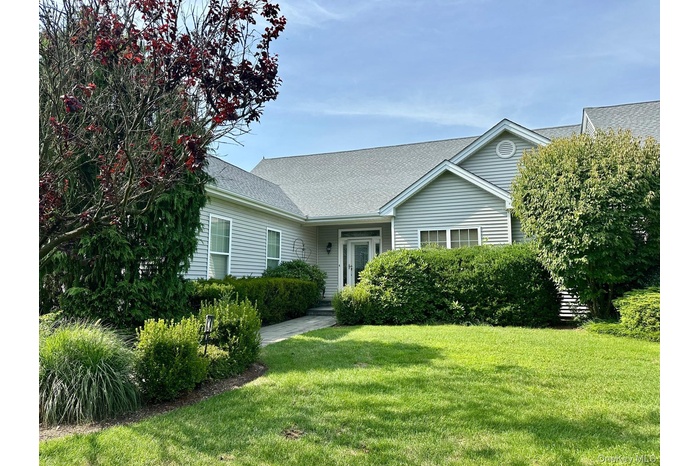 View of front of property featuring a shingled roof and a front yard