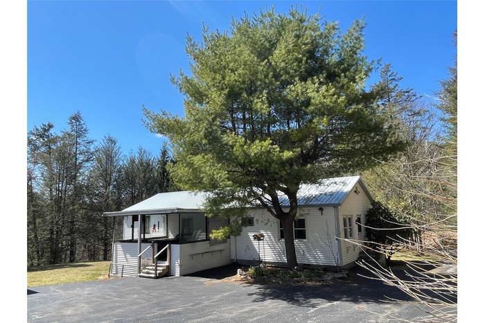 View of front of house featuring entry steps and metal roof