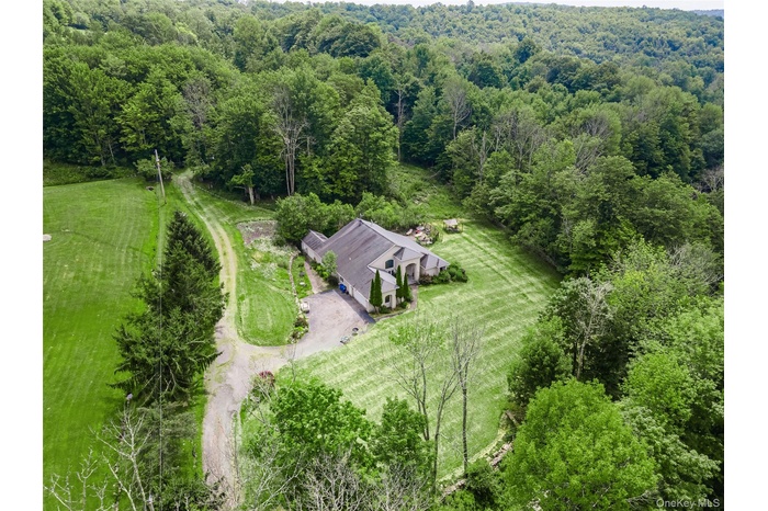 View of subject property with a forest