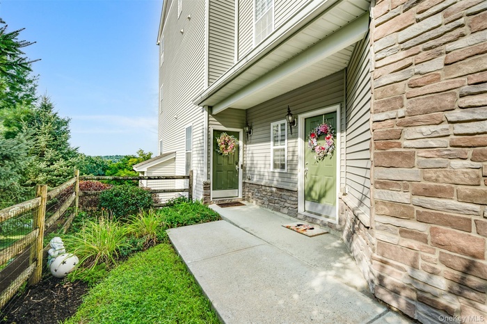 Property entrance featuring stone siding and a porch
