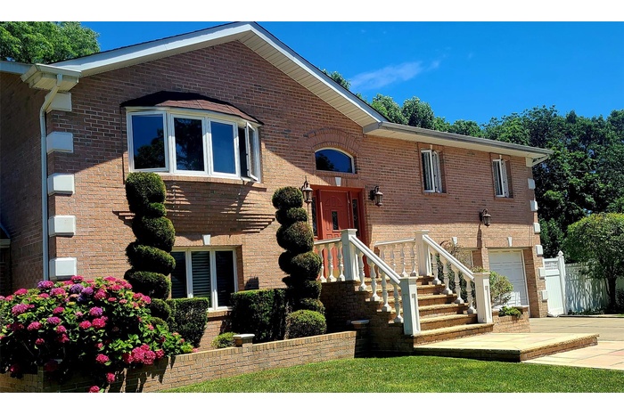 View of front of home featuring an attached garage, brick siding, and concrete driveway