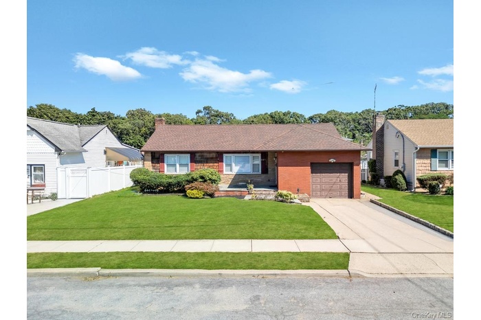 Single story home with concrete driveway, an attached garage, brick siding, a chimney, and roof with shingles