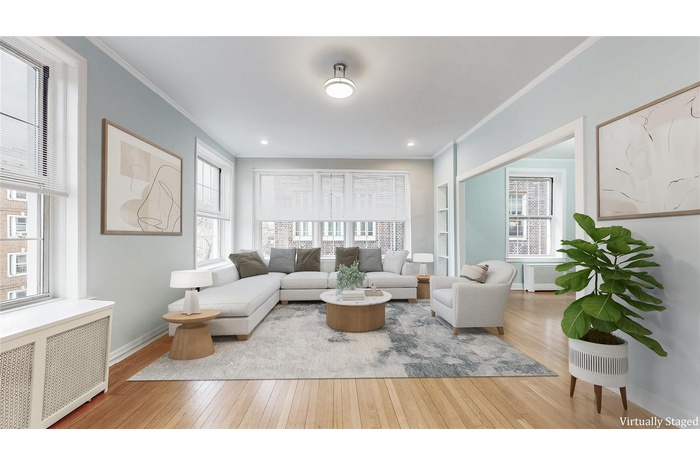 Living room with crown molding, hardwood / wood-style flooring, radiator, and baseboards