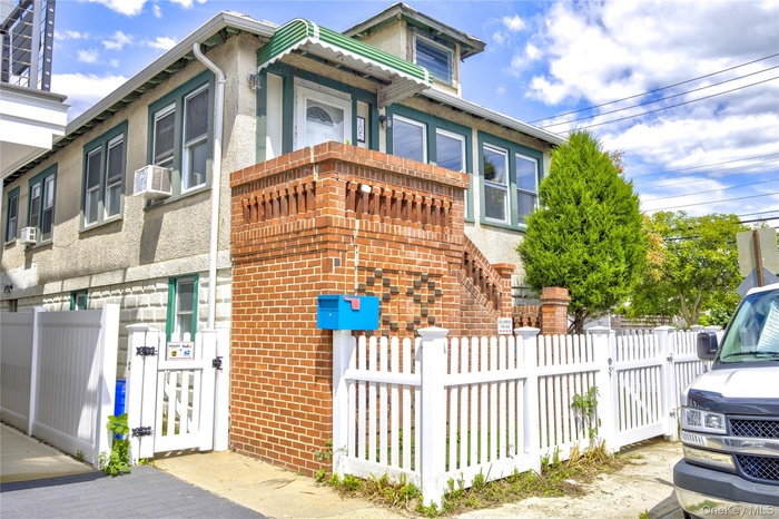 View of front of house featuring a fenced front yard, a gate, and brick siding
