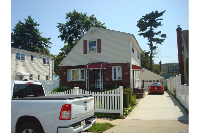 View of front facade featuring a fenced front yard and brick siding