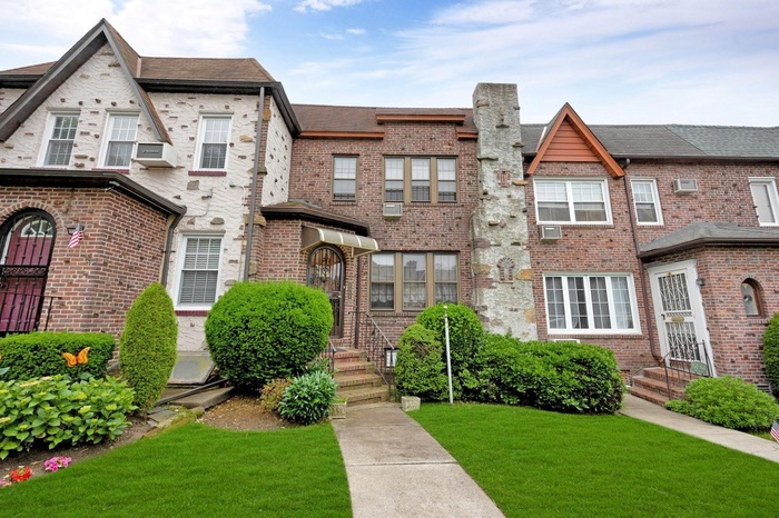 View of front of property featuring a front lawn and brick siding