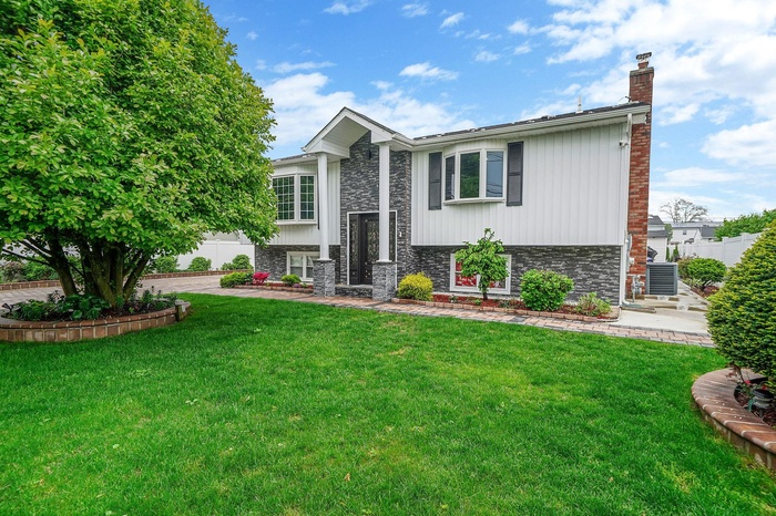 Split foyer home with a chimney and brick siding
