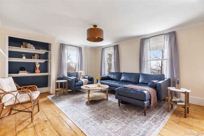 Living area featuring crown molding and light wood-type flooring