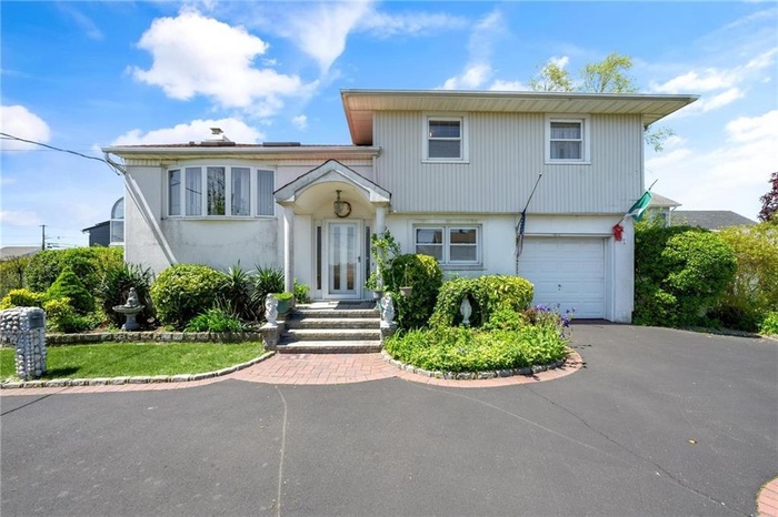 View of front of house featuring a garage, driveway, and stucco siding