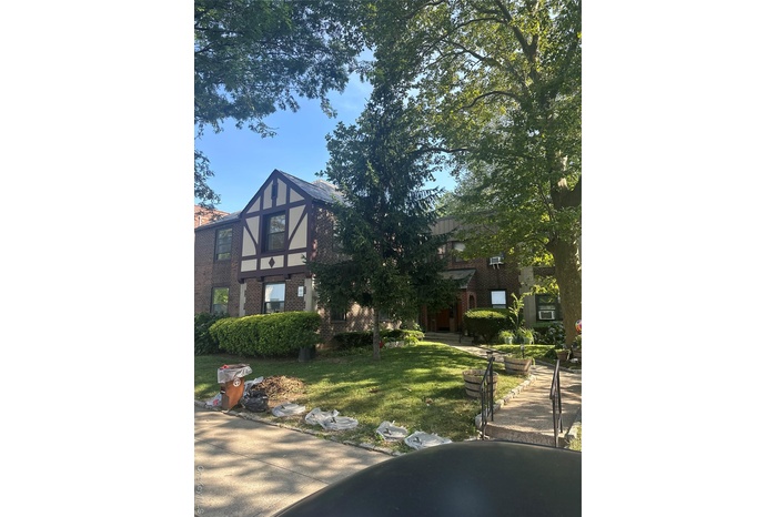 View of front of home with brick siding and a front yard