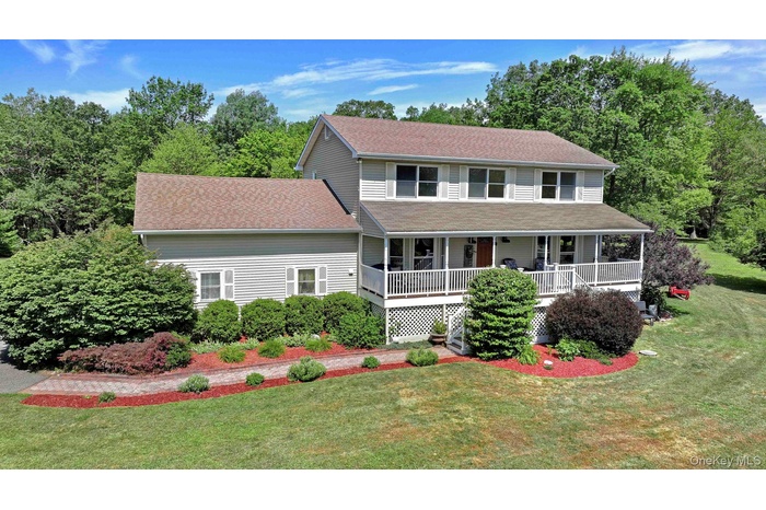 View of front of house featuring a porch, a shingled roof, and a front yard