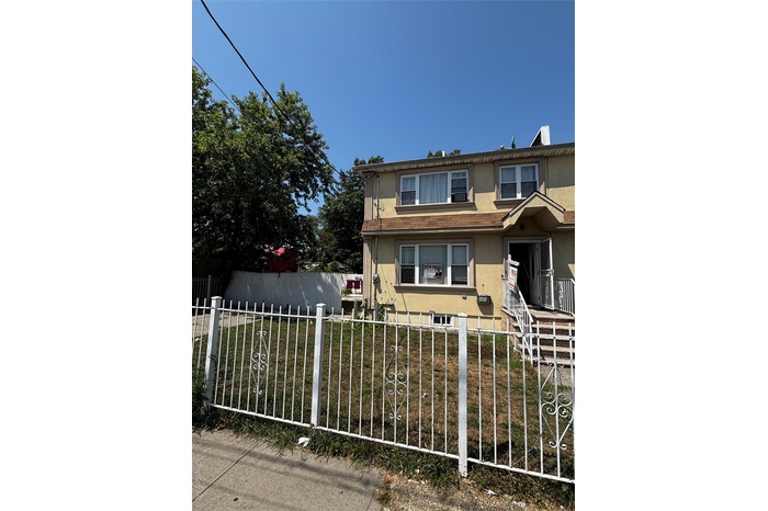 View of front of house with a fenced front yard and stucco siding
