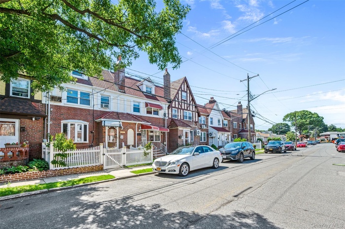 View of asphalt road with street lighting, sidewalks, curbs, a residential view, and a gate
