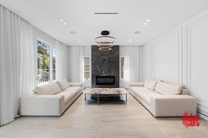 Living area featuring a premium fireplace, a decorative wall, and recessed lighting