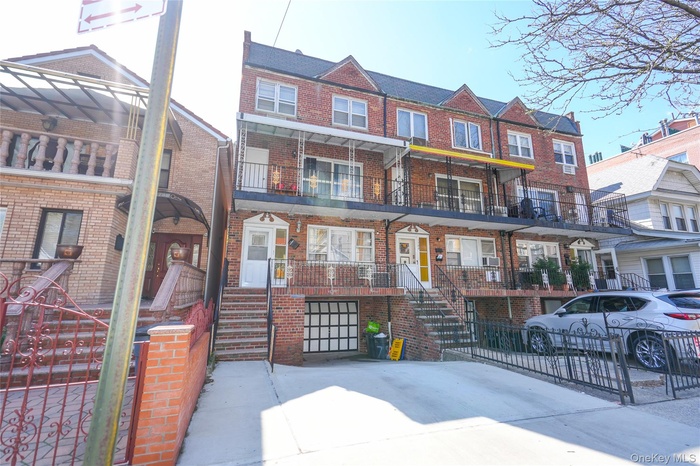 Traditional home with brick siding, a balcony, and stairway