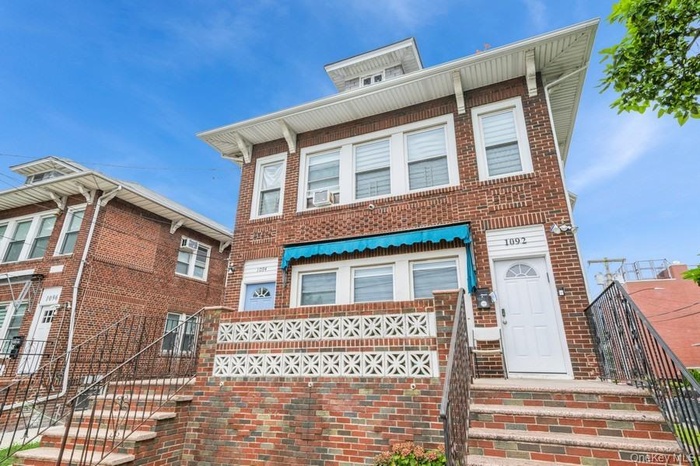 View of front of house featuring brick siding and stairs