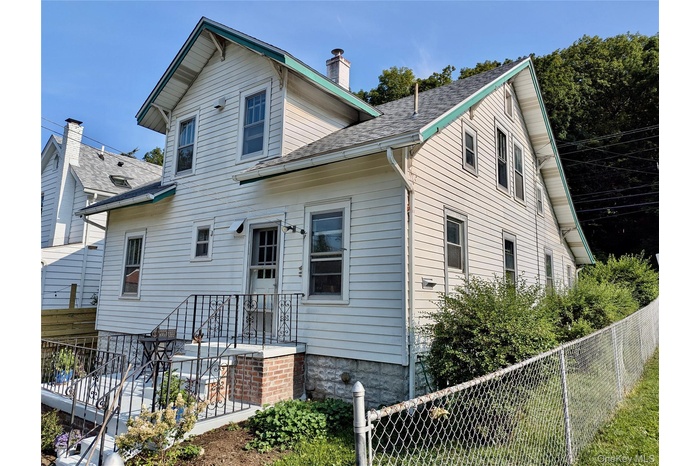 Rear view of house featuring roof with shingles and a chimney