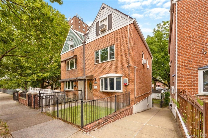 View of front of property featuring a gate, a fenced front yard, and brick siding