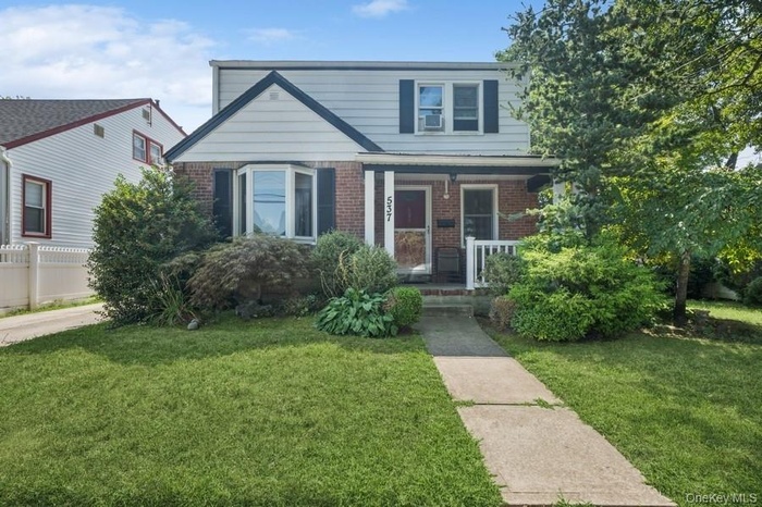 View of front of house featuring brick siding and covered porch