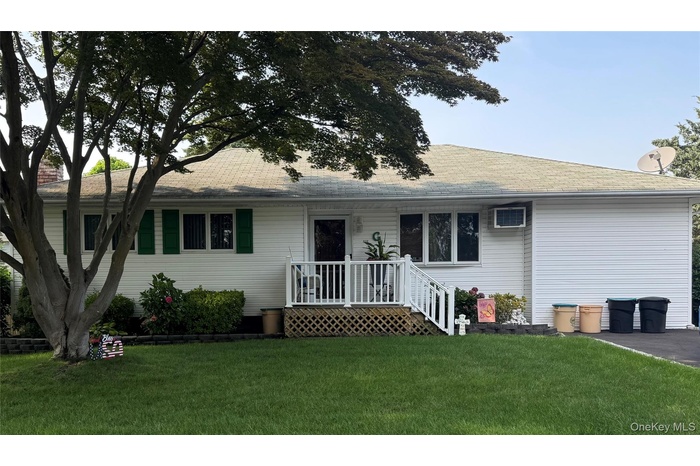 Ranch-style home featuring a front lawn and roof with shingles