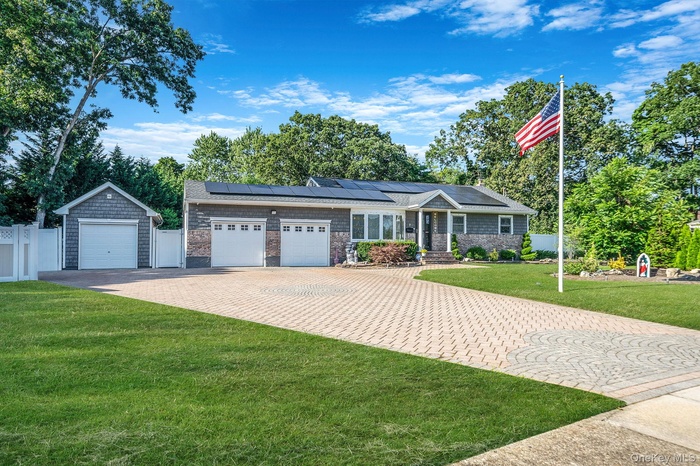 Single story home with solar panels, driveway, and an attached garage
