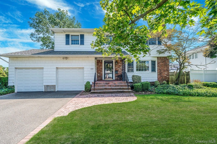 Traditional-style house featuring asphalt driveway, a garage, and a shingled roof