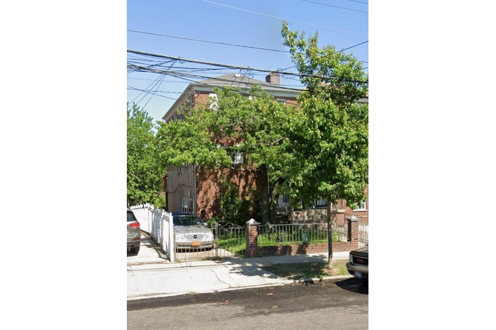 Obstructed view of property with a fenced front yard, a chimney, and brick siding