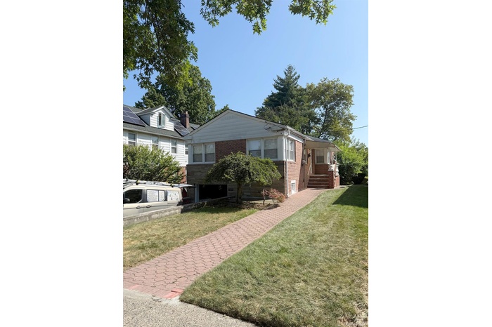 View of front of property featuring brick siding and a front yard