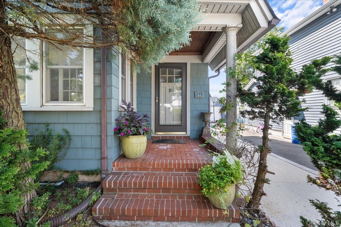 Doorway to property featuring covered porch