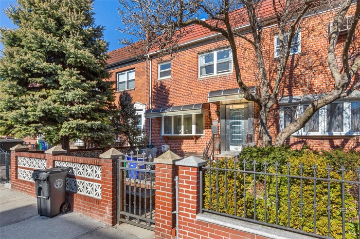 Multi unit property featuring brick siding, a fenced front yard, and a gate
