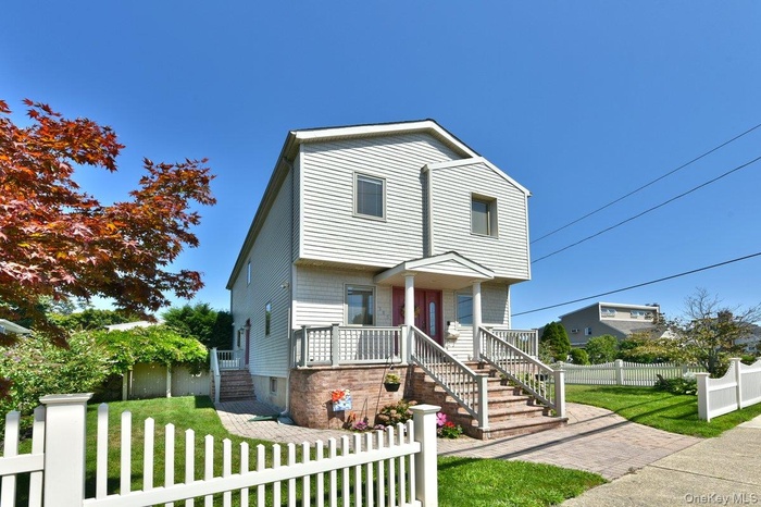 View of front of house with a fenced front yard, covered porch, and stairway