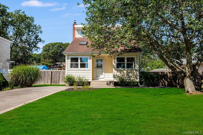 View of front of house featuring a chimney and roof with shingles
