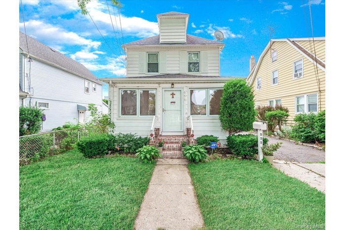 American foursquare style home with entry steps and a shingled roof