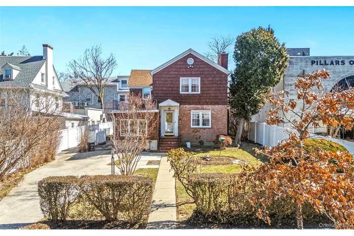 View of front of home with a chimney and brick siding
