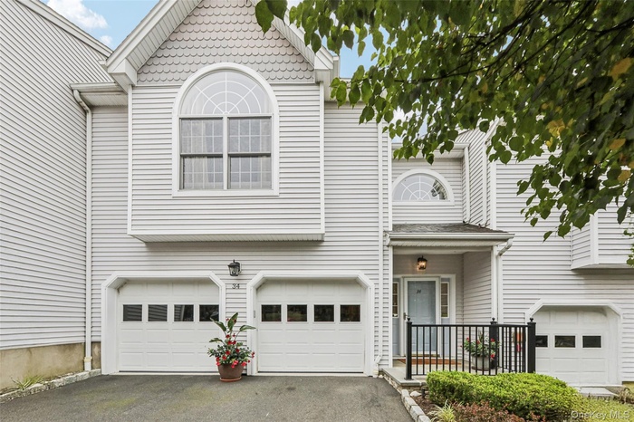 View of front of property with driveway and an attached garage