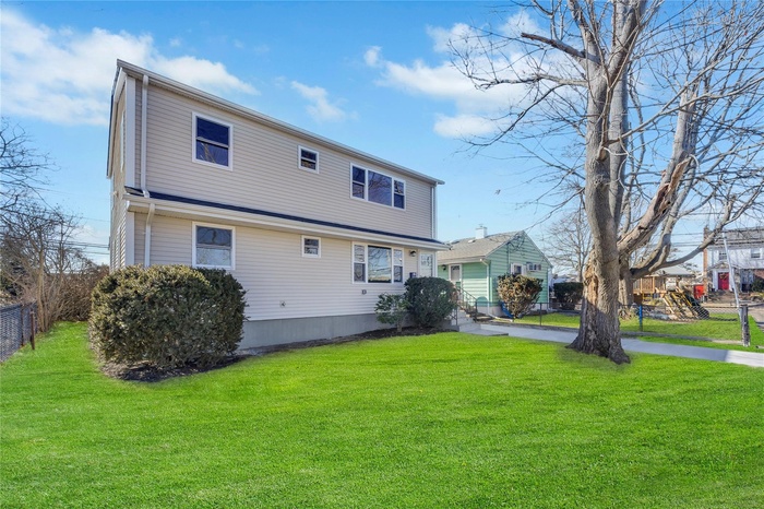 Back of property featuring a yard and fence