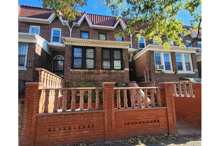 Townhome / multi-family property with cooling unit and brick siding