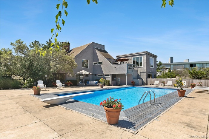 View of swimming pool with a diving board and a patio area