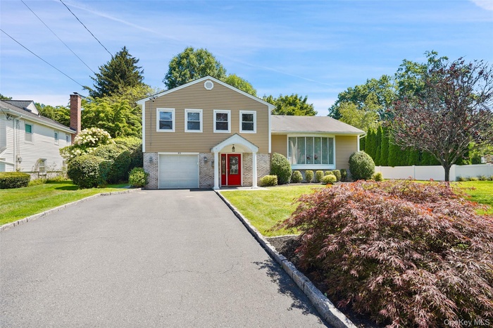 View of front of house with brick siding, a garage, and driveway