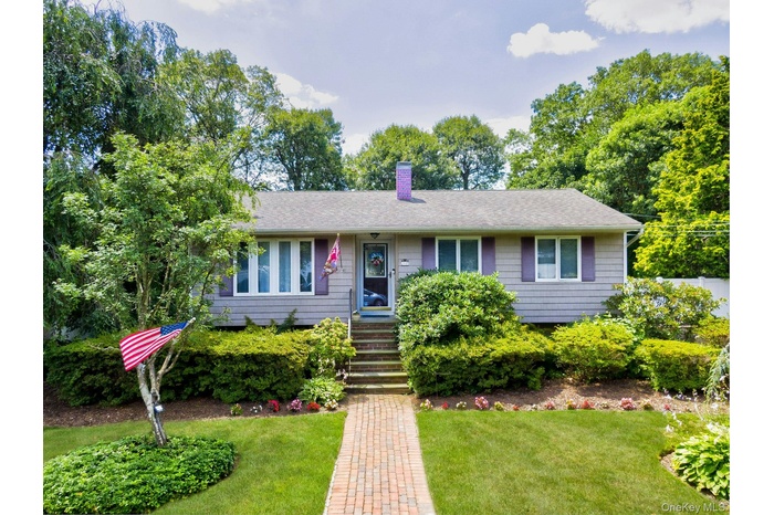 Single story home featuring a front lawn, a chimney, and a shingled roof