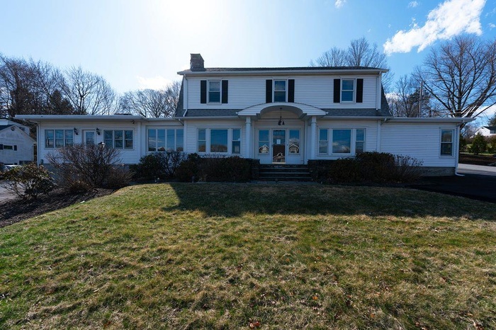 View of front of property featuring a chimney and a front yard