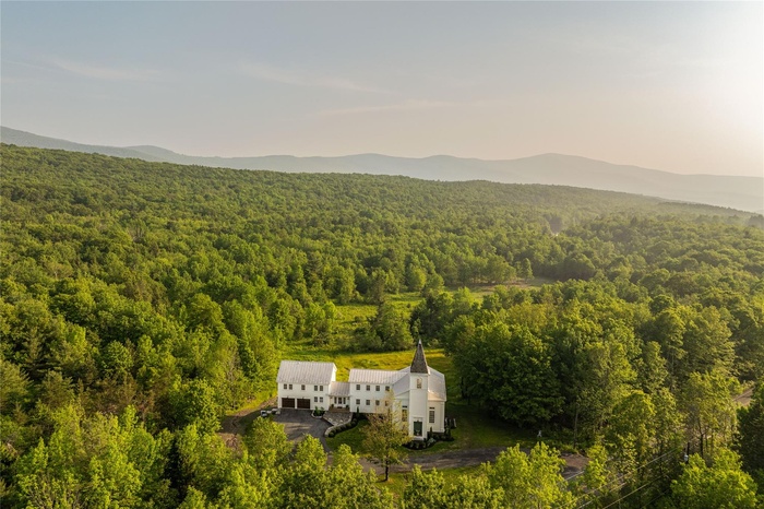 View from above of property featuring a forest and a mountainous background