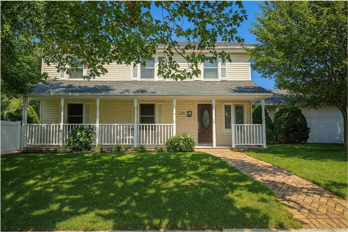 Traditional-style home with covered porch and a front yard