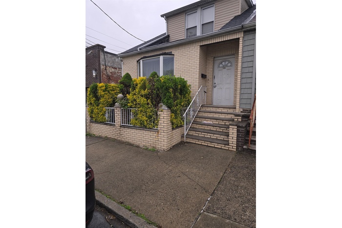 View of exterior entry with brick siding and fence