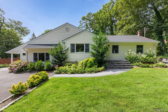 View of front of property featuring a chimney and a shingled roof