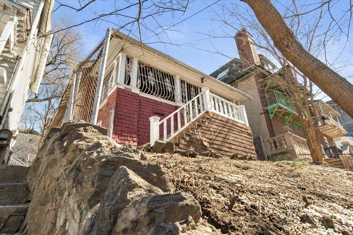 View of side of property with stairs and a chimney
