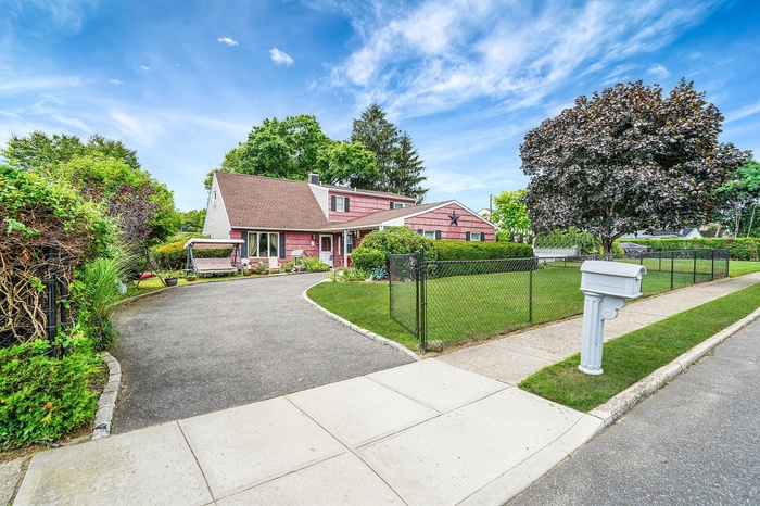 View of front of property with asphalt driveway and a chimney