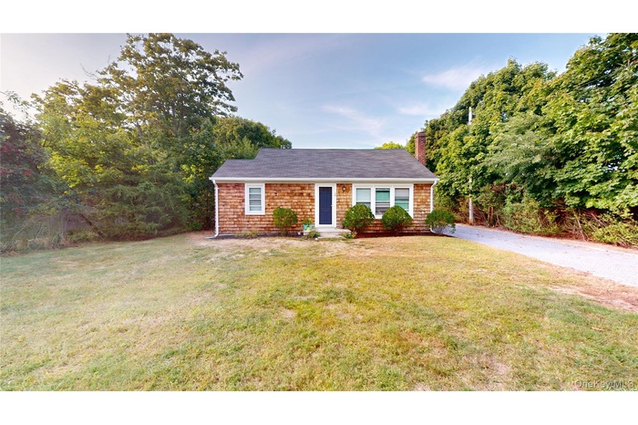 View of front of house featuring a front yard and a chimney