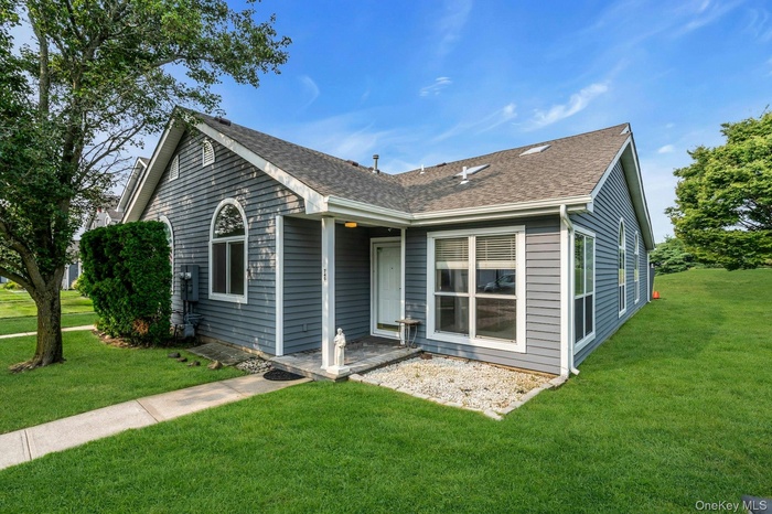 Rear view of property with a lawn and roof with shingles